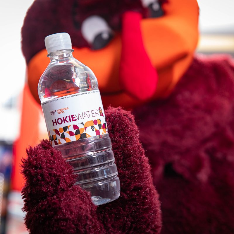 A photo of a Hokie Water bottle with a blurry outdoor background