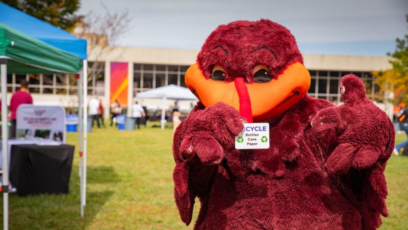The Hokie Bird holding a recycling badge