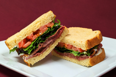 Photo of sandwich close up with bread, tomato, lettuce, and meat